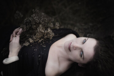 Porträt einer melancholischen Frau auf dem Waldboden liegend - MJF02121