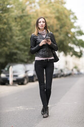 Young woman in the street using smart phone - TAMF00896