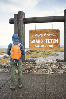 USA, Wyoming, Rückenansicht eines Mannes mit Rucksack, der am Eingang des Grand Teton National Park steht - EPF00194