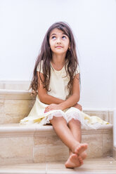 Brünettes Mädchen sitzt auf der Treppe und schaut nach oben - SIPF01164