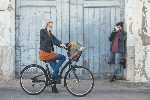 Young man taking a photo of his girlfriend on a bike stock photo