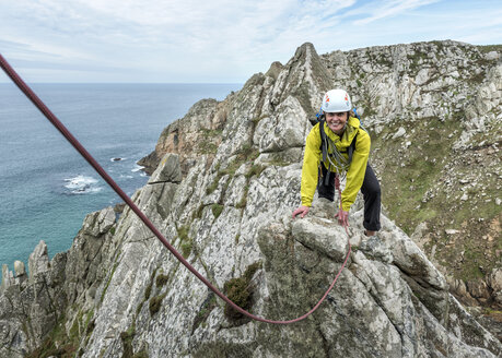 UK, Cornwall, smiling woman climbing on Commando Ridge - ALRF00746