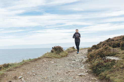 Irland, Howth, Frau läuft auf Küstenpfad - MADF01292