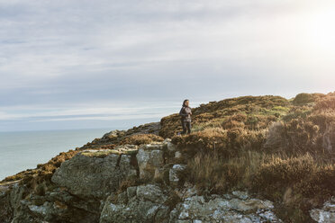 Ireland, Howth, woman running on coastal path - MADF01305