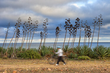 Spain, Andalusia, Natural Park of Cabo de Gata-Nijar, Playa de los Genoveses, man with bicycle passing - DSG01352