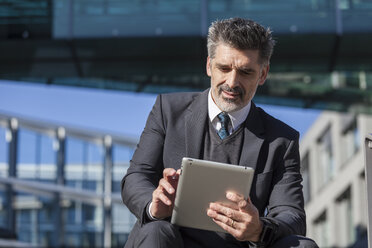 Businessman outdoors using tablet - TCF05224