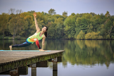 Frau übt Yoga auf einem Steg an einem See - VTF00574