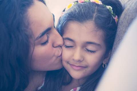 Teenager-Mädchen küsst ihre kleine Schwester, lizenzfreies Stockfoto