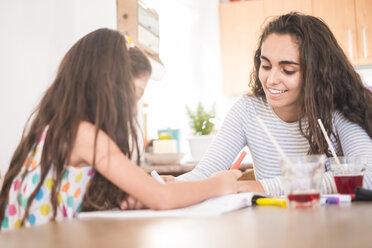 Teenage girl and her little sister drawing together - SIPF01194