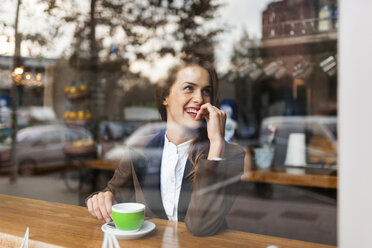 Lächelnde junge Frau in einem Kaffeehaus - VABF00913