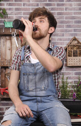 Young gardener taking a break drinking beer - RTBF00583