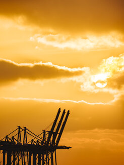 Deutschland, Hamburg, Hafenkräne bei Sonnenuntergang - KRPF02082