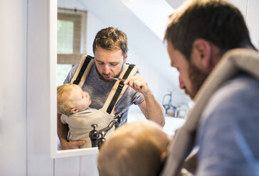 Vater mit Baby im Kinderwagen beim Zähneputzen - HAPF01231