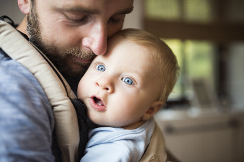 Vater kuschelt mit Baby in Tragetasche - HAPF01234