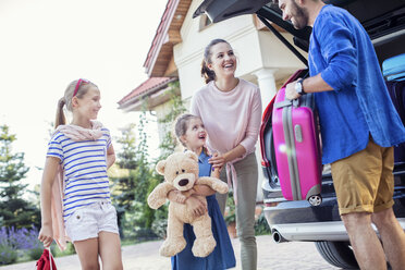 Glückliche Familie packt Auto für Urlaub - WEST22303