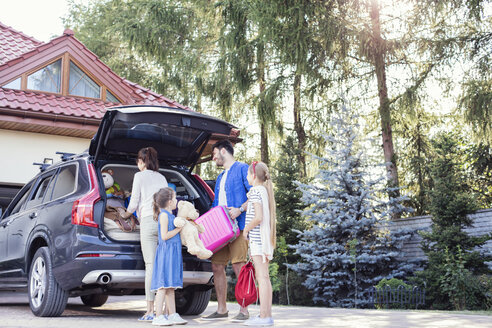 Glückliche Familie packt Auto für Urlaub - WEST22304