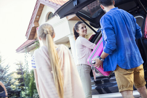 Glückliche Familie packt Auto für Urlaub - WEST22305