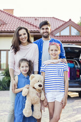 Glückliche Familie vor einem für den Urlaub gepackten Auto - WEST22309