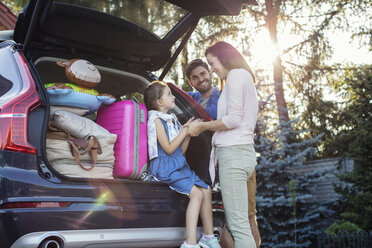 Glückliche Familie packt Auto für Urlaub - WEST22318