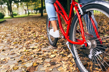 Beine einer Frau beim Radfahren in einem Park im Herbst - MGOF02694