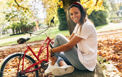 Portrait of smiling young woman in a park in autumn - MGOF02716