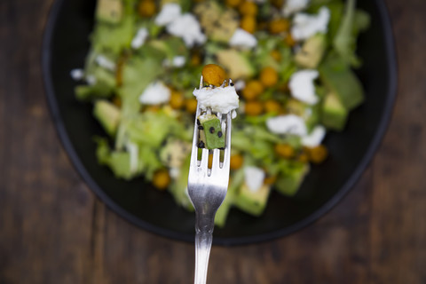 Roasted chick-pea, avocado, feta and black sesame skewered with fork stock photo