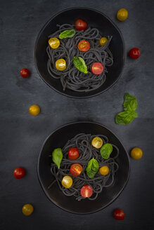 Zwei Schüsseln Spaghetti al Nero di Seppia mit Tomaten und Basilikumblättern - LVF05717