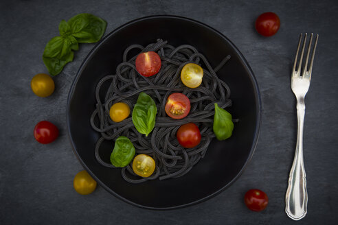 Schüssel mit Spaghetti al Nero di Seppia mit Tomaten und Basilikumblättern - LVF05720