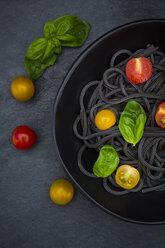 Schüssel mit Spaghetti al Nero di Seppia mit Tomaten und Basilikumblättern - LVF05721