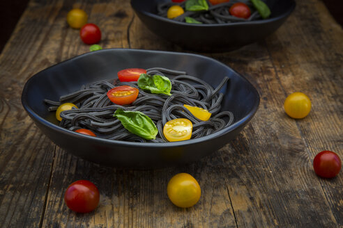 Schüssel mit Spaghetti al Nero di Seppia mit Tomaten und Basilikumblättern - LVF05724