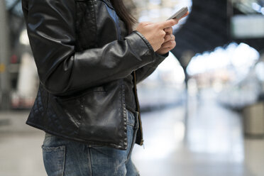 Frau benutzt Mobiltelefon am Bahnhof - KKAF00185