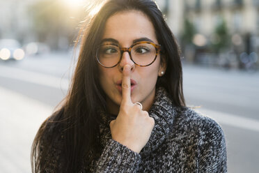 Porträt einer jungen Frau mit Brille, die Gesichter zieht - KKAF00195