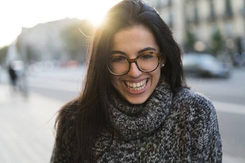 Porträt einer glücklichen jungen Frau mit Brille im Freien - KKAF00196