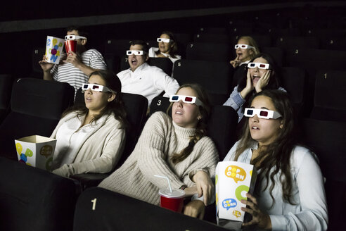 Verängstigte Menschen mit 3D-Brillen, die sich einen Film im Kino ansehen - ABZF01637