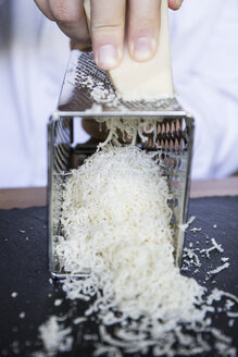 Die Hände eines Mannes reiben Käse während einer handgemachten Pasta kochen - ABZF01642