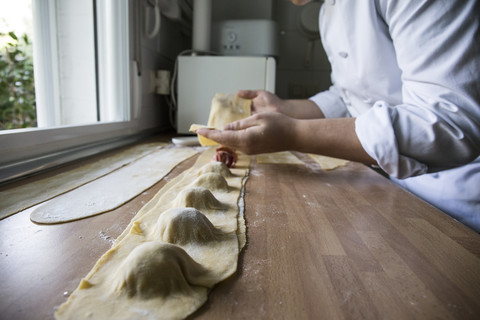 Mann bereitet in der Küche handgemachte Ravioli zu, lizenzfreies Stockfoto