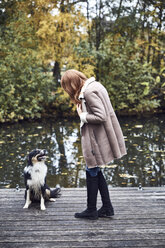 Frau mit ihrem Hund auf dem Bootssteg im Herbst - SRYF00142