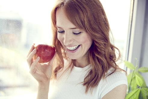 Portrait of redheaded woman with red apple - SRYF00150