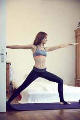 Redheaded woman doing yoga exercise at home - SRYF00172