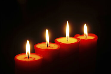 Reihe von vier brennenden roten Kerzen - JTF00792