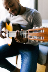 Junger Mann spielt zu Hause Gitarre - VABF00954