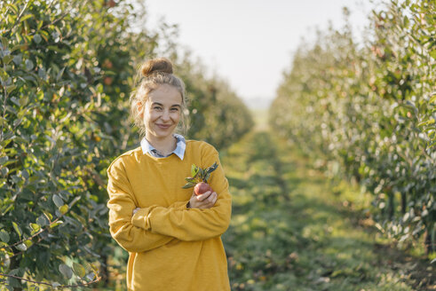 Porträt einer lächelnden jungen Frau im Apfelgarten - KNSF00730