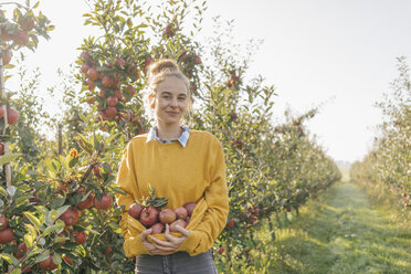 Junge Frau hält Äpfel im Obstgarten - KNSF00737