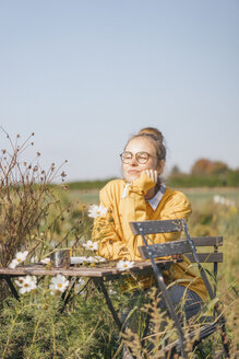 Young woman relaxing in cottage garden - KNSF00765