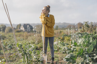 Young woman with spade in cottage garden - KNSF00776