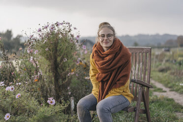 Junge Frau entspannt sich im Garten einer Hütte - KNSF00783