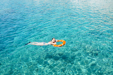 Griechenland, Milos, Frau schwimmt auf dem Wasser - GEMF01321