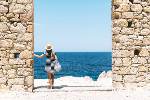 Griechenland, Milos, Firopotamos Beach, Frau steht in Tür in Steinmauer, schaut in die Ferne - GEMF01333