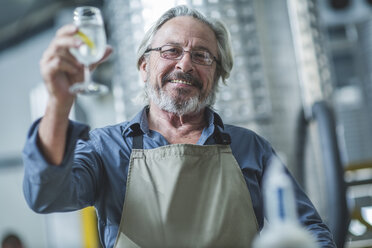 Schnapsbrenner stößt mit einem Glas Schnaps an - ZEF11865