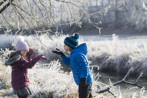 Brother and little sister playing together in winter stock photo